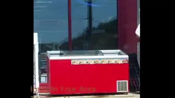 Funcionário do posto de gasolina limpando um refrigerador